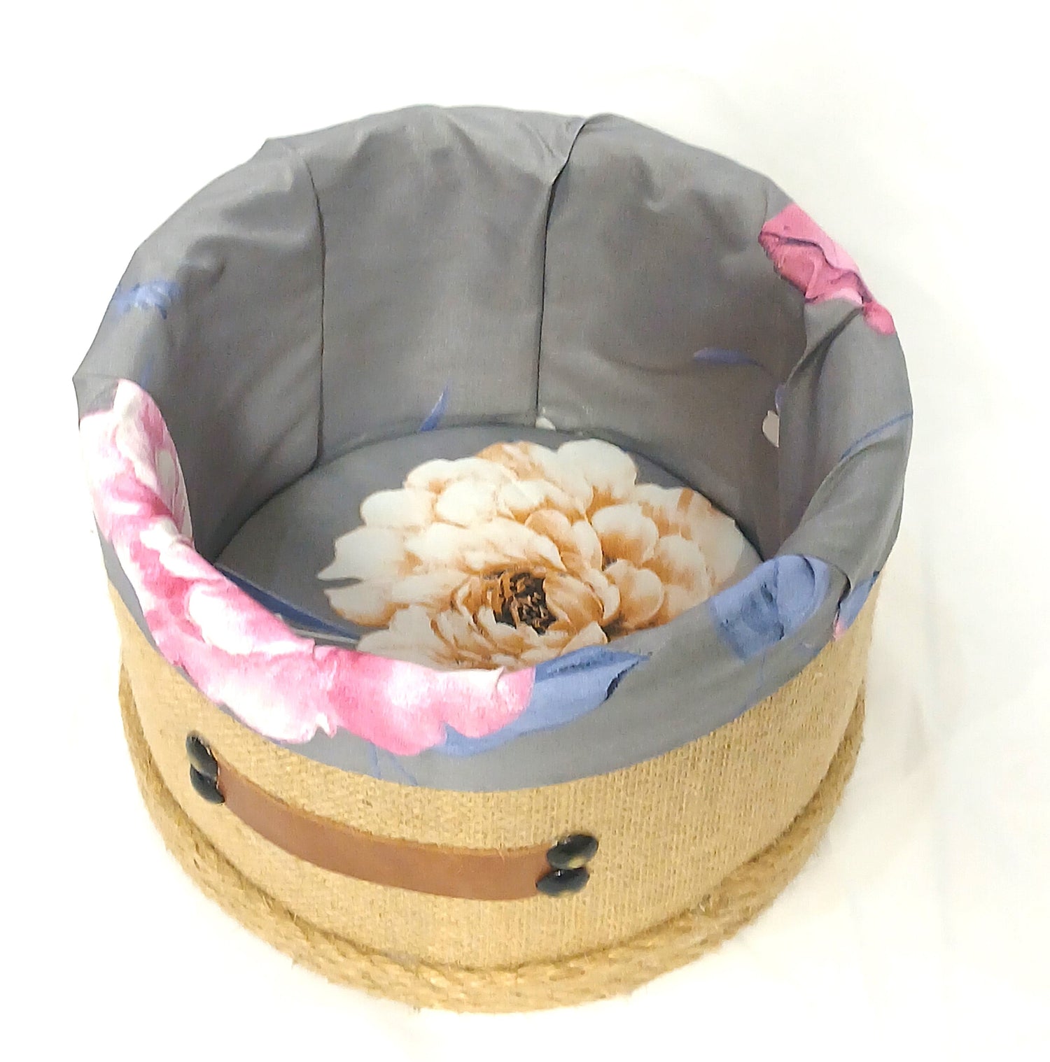 Jute storage basket with floral fabric liner and decorative dried flower